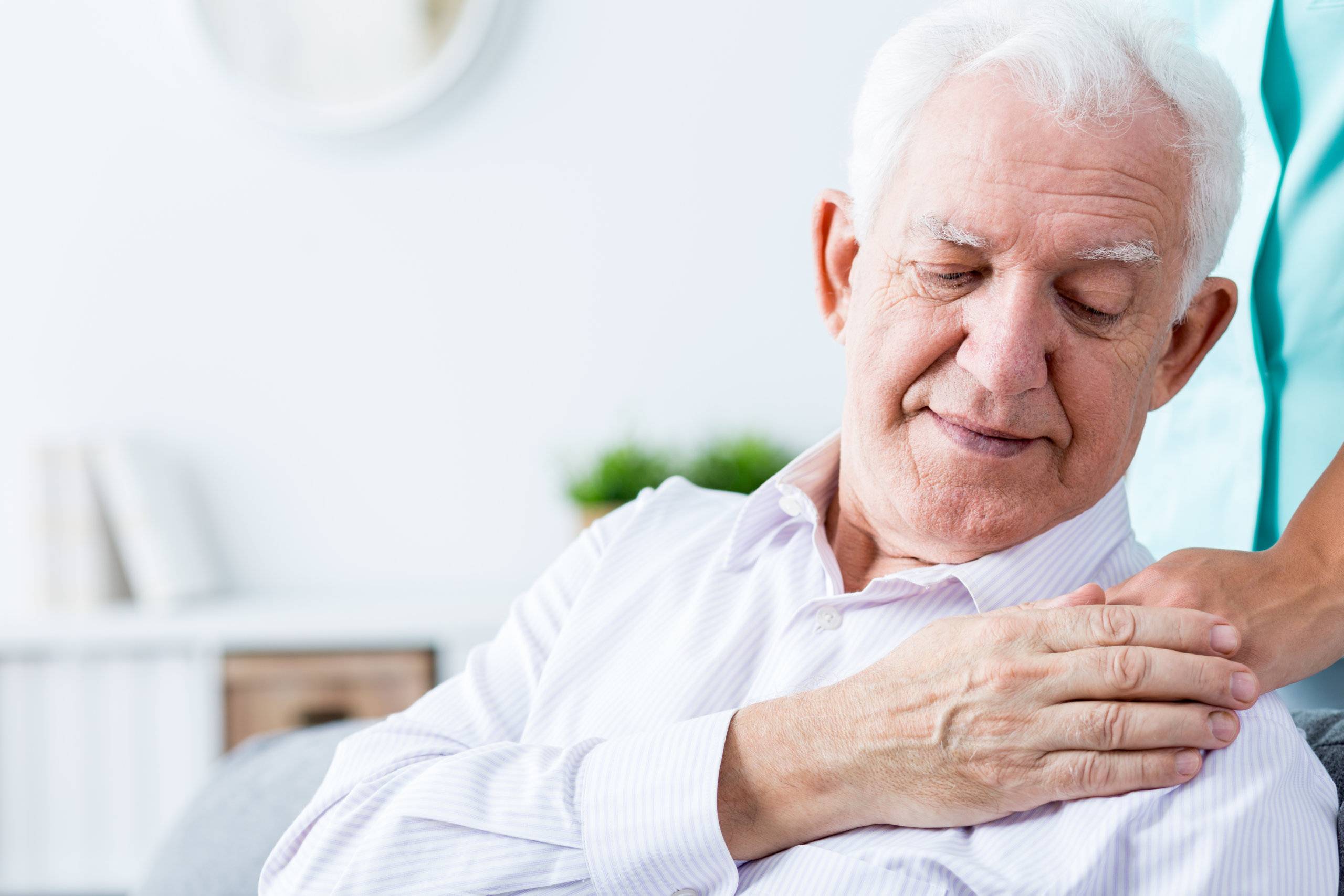 senior man putting his hand on his caregiver's hand