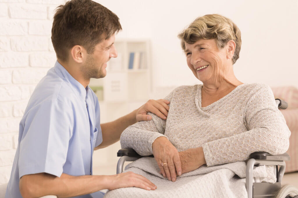 Caregiver comforting elderly woman