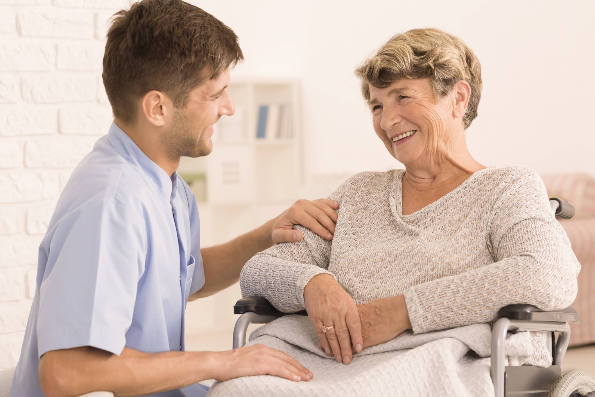 a senior woman and her caregiver smiling
